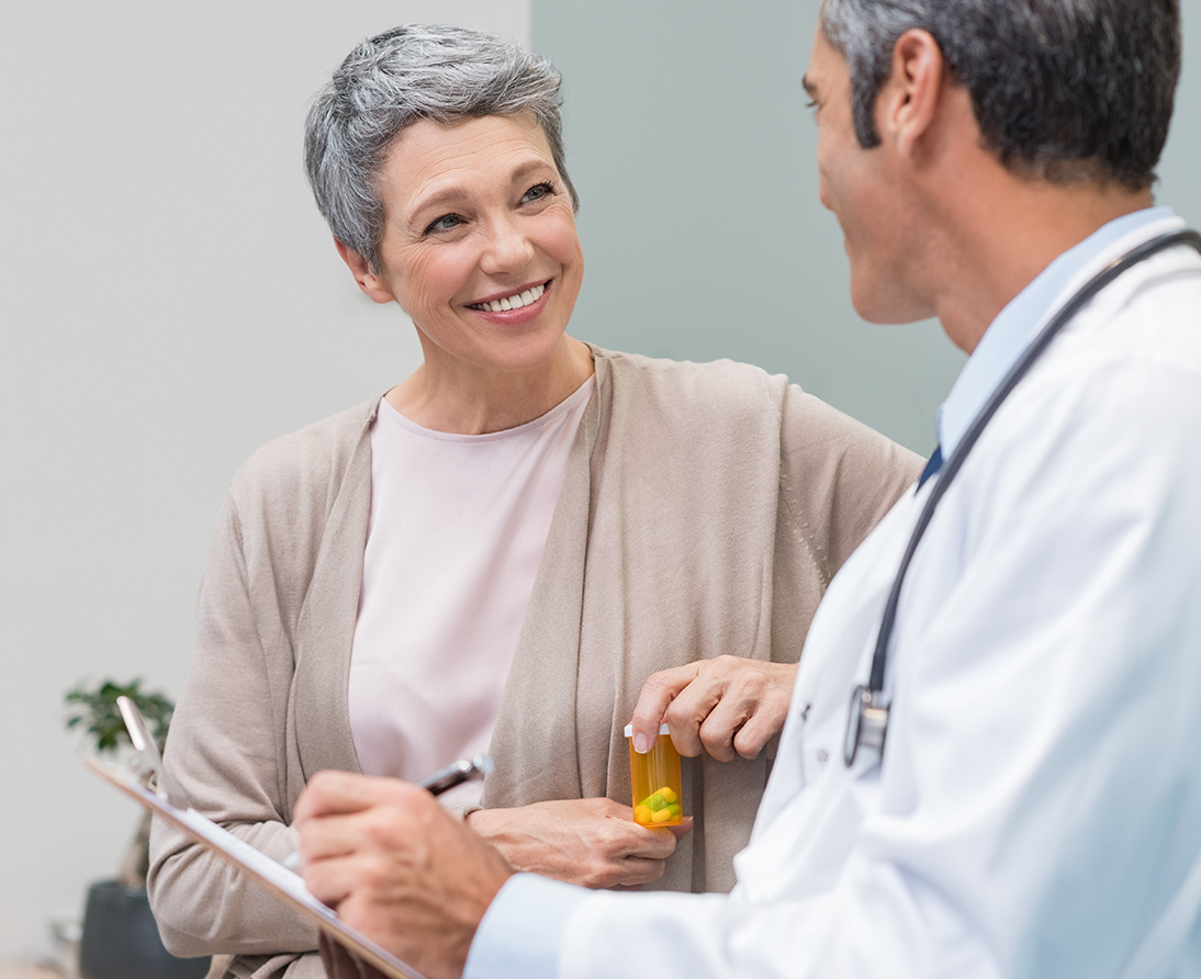 A woman talks to a doctor in a white coat.