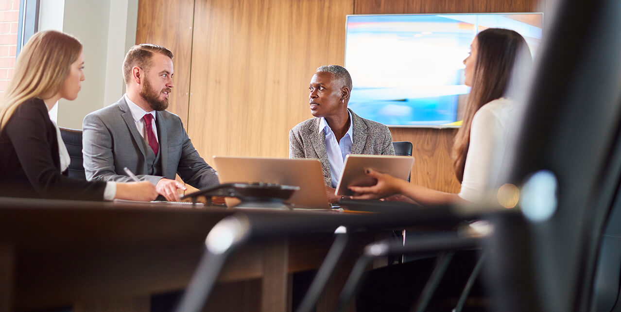 People sit around a conference room table. There are four levels of Social Security Disability appeals.