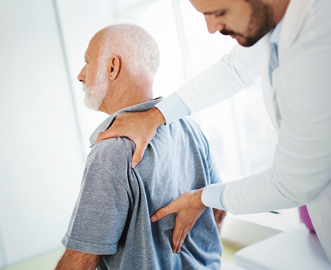 A doctor examines a man's back.